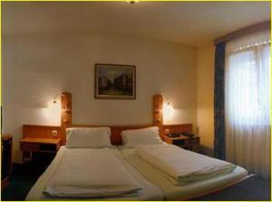 1 dormitorio con 2 camas y ventana en Hotel Domino, en Hanau am Main