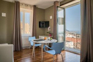 een kamer met een tafel en stoelen en een balkon bij Plaium Montis in Salerno
