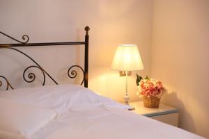 a bedroom with a bed with a lamp and flowers at villa oliveta in San Gimignano