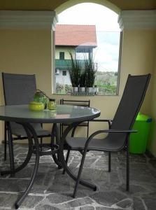 einen Tisch und Stühle in einem Zimmer mit Fenster in der Unterkunft Kellerstöckl Kamper in Eisenberg an der Pinka