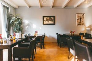 a restaurant with tables and chairs in a room at Galerie Riesling in Trittenheim