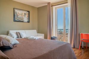 een slaapkamer met een bed en een groot raam bij Plaium Montis in Salerno