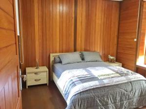 a bedroom with a bed and a wooden wall at APM Equestrian Resort in Tangerang