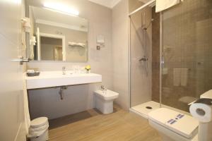 a bathroom with a sink and a toilet and a shower at Hotel Puerta del Mar - Adults Recommended in Nerja