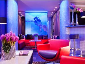 una sala de espera con muebles rojos y una pared azul en ATN Hôtel, en París