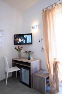 a living room with a desk and a tv on a wall at The Stunning B&B in Peschici