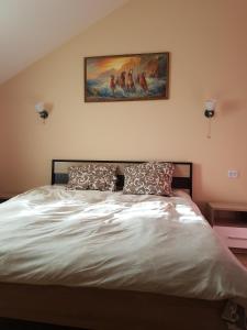 1 dormitorio con 1 cama con una pintura en la pared en Hotel, en Dnipro