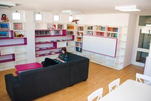 a woman sitting on a couch in a library at Split Summer Budget Rooms in Split