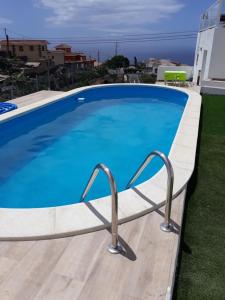 a large blue swimming pool on top of a house at modern holiday apartment with private pool in Adeje