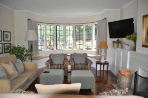 a living room with a couch and chairs and windows at Elgin Country Lodge in Elgin