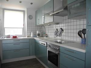 a kitchen with blue cabinets and a stove top oven at Ferienwohnung Spatzennest in Wesel