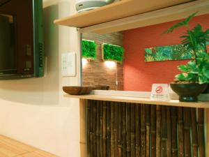 un estante de libros en una habitación con plantas. en Guesthouse Nara Komachi, en Nara