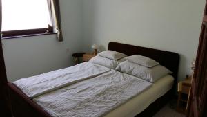1 cama con 3 almohadas en un dormitorio en Lakeside Apartment, en Tihany