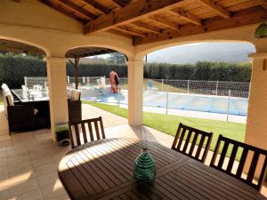 Granès的住宿－Villa Dendrane，一个带桌椅的庭院和一个游泳池