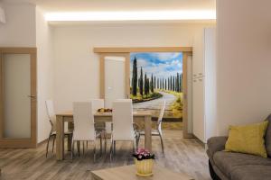 uma sala de jantar com uma mesa e uma pintura de árvores em Residence Hill em San Quirico dʼOrcia