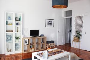 Casa Miratejo - Downtown في لشبونة: غرفة معيشة مع طاولة وتلفزيون