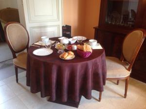 uma mesa com uma toalha de mesa roxa e pão sobre ela em Château du Romerel - Baie de Somme em Saint-Valery-sur-Somme