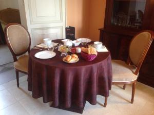 a table with a purple table cloth and bread on it at Château du Romerel - Baie de Somme in Saint-Valery-sur-Somme