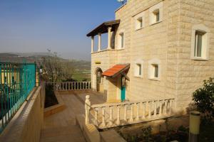 Beautiful Galilea في Deir Ḥannā: مبنى بسور ابيض بجانب مبنى