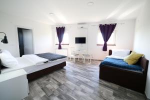 een slaapkamer met 2 bedden en een eettafel bij Guesthouse & restaurant Tekovina in Smederevo
