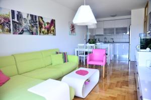 a living room with a green couch and pink chairs at Pure Apartment in Bar