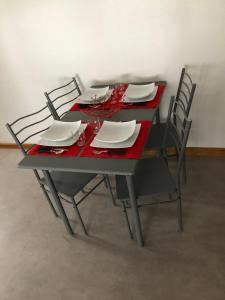 リボーヴィレにあるDuplex à Ribeauvilléのテーブル(椅子4脚、赤いテーブルクロス)