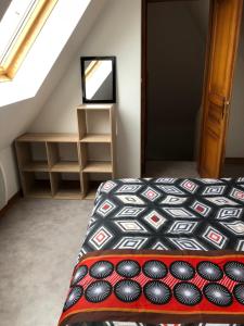 sypialnia na poddaszu z łóżkiem i lustrem w obiekcie Duplex à Ribeauvillé w mieście Ribeauvillé