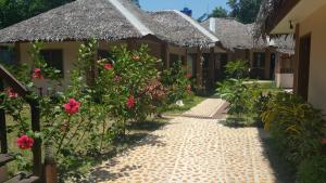 una pasarela frente a un edificio con flores en Rubin Resort en San Vicente