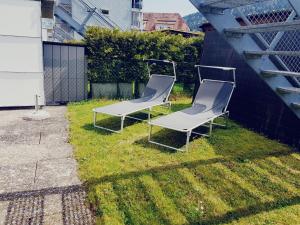 zwei Stühle auf dem Rasen im Garten in der Unterkunft Jac-Cosy in Fleurier