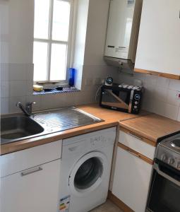 cocina con lavadora y fregadero en One bedroom house in pretty Oxfordshire village - super fast broadband, en Didcot