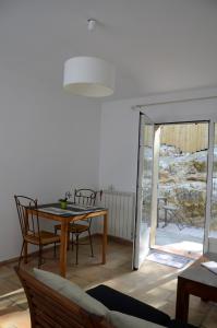 a living room with a table and chairs and a balcony at Mas du Puech Clapas in Assas