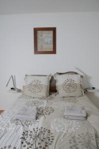 a white bed with two pillows and a picture on the wall at Mas du Puech Clapas in Assas +28 photos
