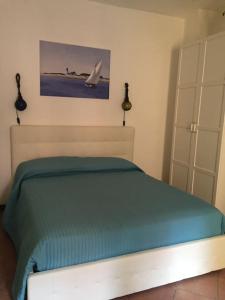um quarto com uma cama com um cobertor verde em Relax al mare em Giglio Porto