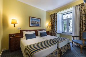 um quarto de hotel com uma cama e uma janela em Residencial Florescente em Lisboa