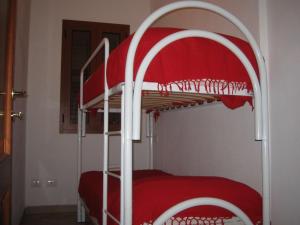 two bunk beds in a room with red sheets at Recidence il gabbiano in Valledoria +5 photos