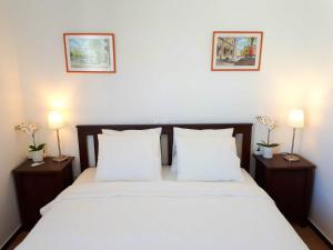 a bedroom with a white bed with two night stands at City Beach Home 60 in Las Palmas de Gran Canaria