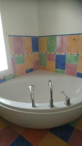 y baño con bañera y 2 grifos. en Chambre d'Hôtes Les Bruyères, en Cadouin