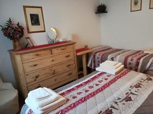 um quarto com 2 camas e uma cómoda e toalhas em Kèbele em Roana