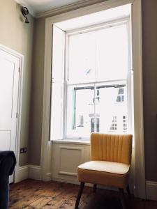 une chaise assise devant une grande fenêtre dans l'établissement The Butler's House, à Ulverston