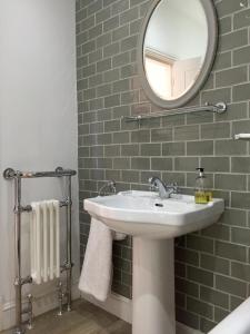La salle de bains est pourvue d'un lavabo et d'un miroir. dans l'établissement The Butler's House, à Ulverston
