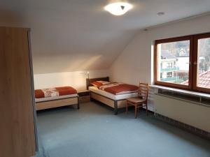 Schlafzimmer im Dachgeschoss mit 2 Betten und einem Fenster in der Unterkunft Ferienhaus Müller in Unkel