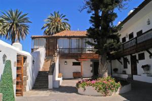 ein Haus mit Treppen, einem Baum und Blumen in der Unterkunft Cortijo San Ignacio in El Cortijo