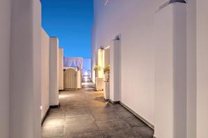 a hallway with white walls and a tile floor at Santorini Blue Senses Villas in Mesaria