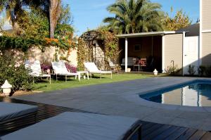 un patio trasero con piscina y una casa en Delvino Boutique Hotel en Salta