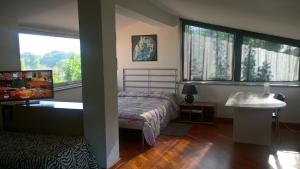 1 dormitorio con cama, lavabo y ventanas en Villa Cardinal Apartments, en Tívoli