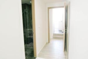 a hallway with a glass door leading to a bathroom at Comfy Studio 4 by Ong Realty in Singapore +18 photos