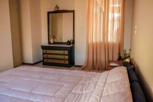 a bedroom with a bed and a sink and a mirror at Evgenia's Balcony in Preveza
