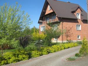 a brick house with a black roof and a brick road at Noclegi na Debinie in Gorzyce