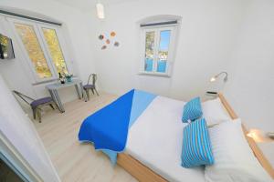 a bedroom with a bed with blue and white pillows at Sea View Studio Apartment in Zadar
