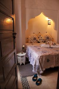 ein Schlafzimmer mit einem Bett und einem Paar Schuhe in der Unterkunft Riad El Arco ROOFTOP POOL & Spa in Marrakesch